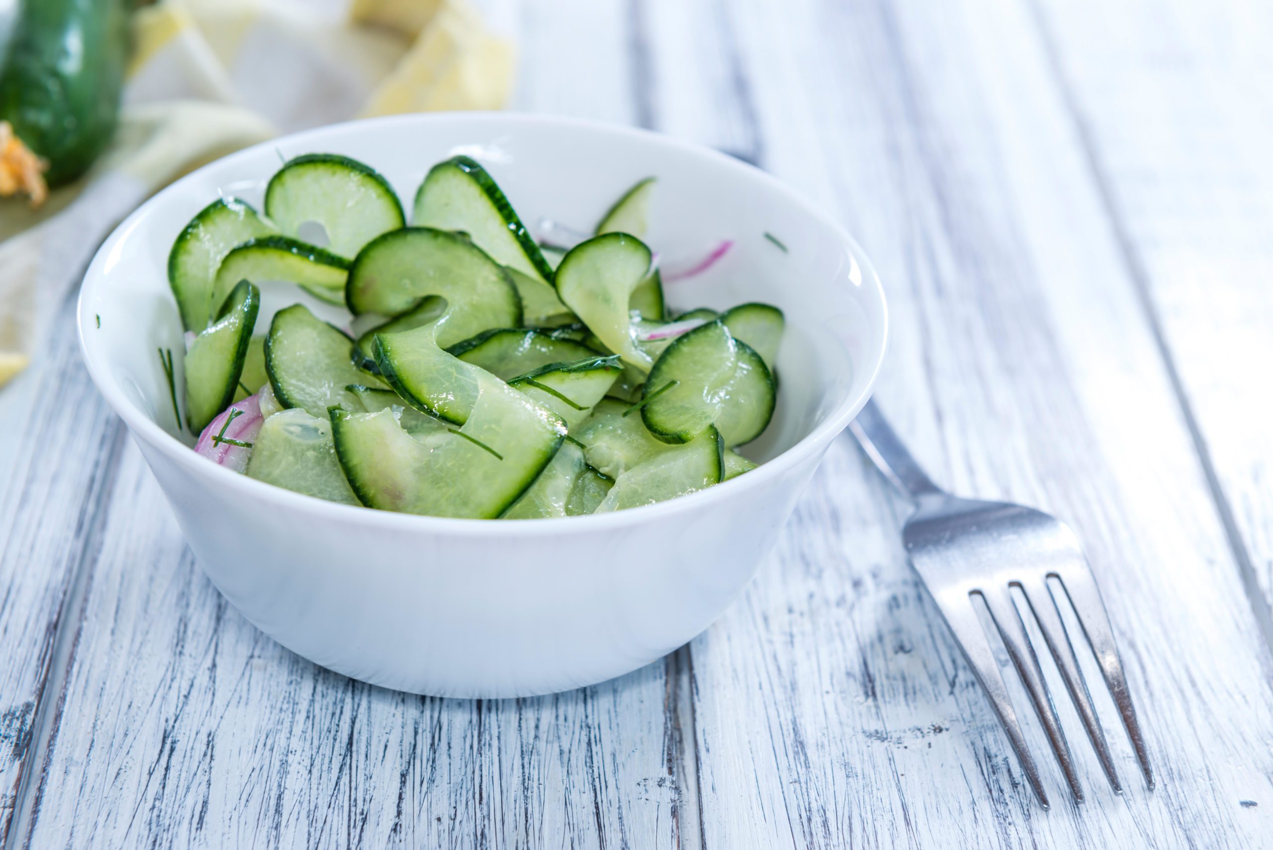 Homemade Cucumber Salad with onions and dill on a wooden table